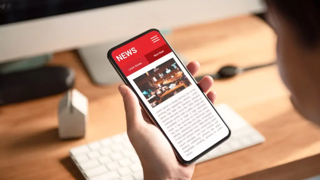 スマホから最新ニュースを眺めている画像