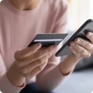 スマホとクレジットカードを持つ人の手元