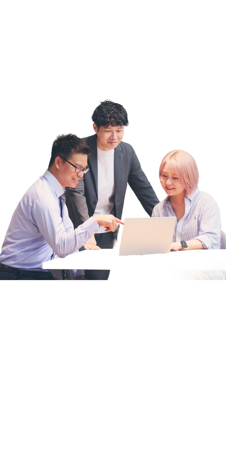ノートPCの画面を指さしながら打ち合わせをする3人の社員