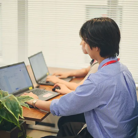 オフィスでノートPCを使って集中して作業する男性社員