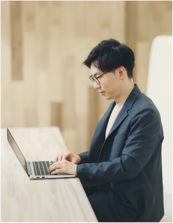 あごに手を当てパソコンの画面を見つめる男性社員