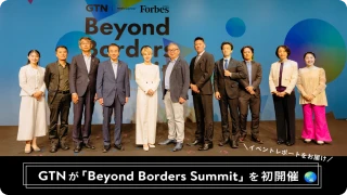 スーツ姿の登壇者が並ぶ集合写真に「Beyond Borders!」の文字が重なっている