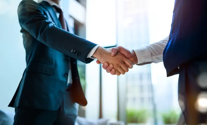 女性がパソコンを見ながら電話している画像